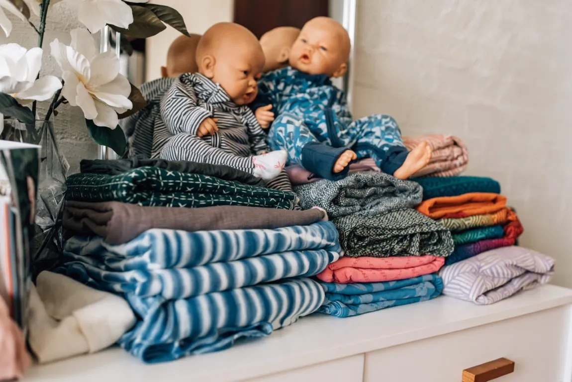Dolls sitting on top of carrier wraps
